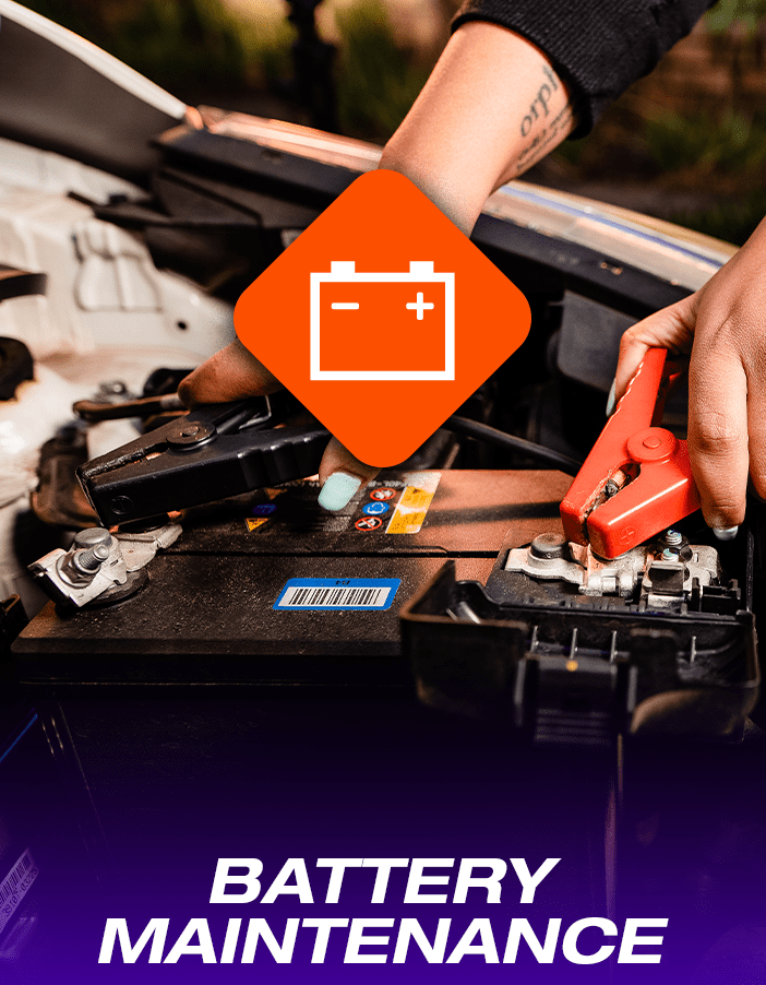 A Tyres & More technician performing battery maintenance , attaching jumpers to a battery.