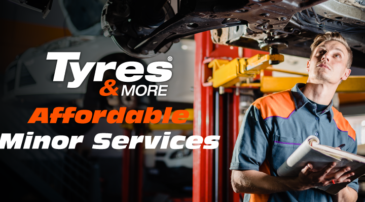 A tyres & more technician looking beneath a lifted vehicle